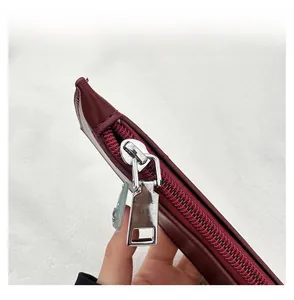 Macro detail of high-quality silver zipper on dark red leather punk style bucket bag