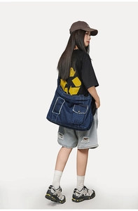 Détail du sac fourre-tout en denim bleu foncé avec poches cargo et boutons en métal