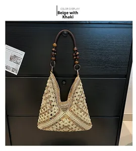 Detail of hand-woven straw tote bag with beige khaki patterns and wooden bead handles