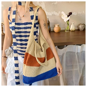 Detail of hand-woven striped beach tote bag with artisanal crochet texture and fringe