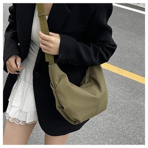 Detailed close-up of an olive green corduroy crescent bag with a minimalist design