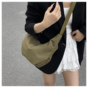 Olive green crescent dumpling bag with ribbed texture worn by model over shoulder