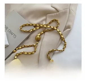 Detail van gele gewatteerde leren tas met gouden ketting en metalen verstelbal