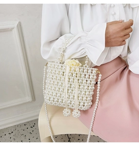Détail du sac seau en perles fait main avec doublure en satin et bandoulière chaîne