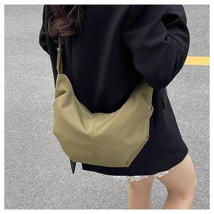 Outdoor view of Morandi green nylon crescent bag with adjustable strap and casual style