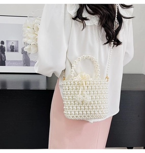 Détail du sac seau perlé blanc fait main avec pochette en satin et bandoulière en chaîne