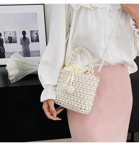 Détail du sac seau en perles fait main blanc avec doublure à cordon et bandoulière chaîne