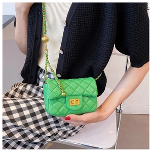 Detail van heldergroene gewatteerde crossbodytas met gouden ketting en bolsluiting