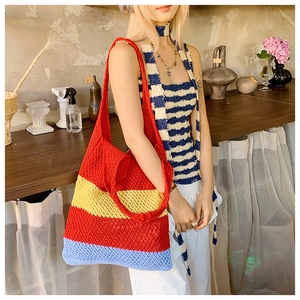 Detailed knit texture of large tote bag with red, yellow and blue crochet stripes