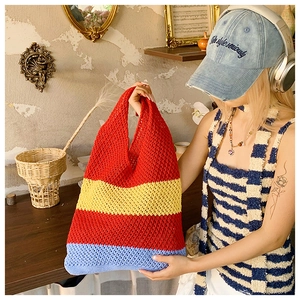 Detail of hand-crocheted tote bag featuring red yellow and blue striped mesh texture