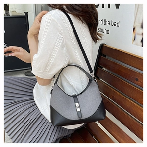 Détail du sac patchwork en sergé gris et cuir noir avec fermoir argenté sur un modèle