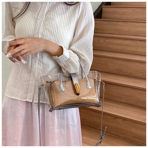 Détail du sac seau en PVC transparent avec pochette intérieure tissée marron et garniture en cuir