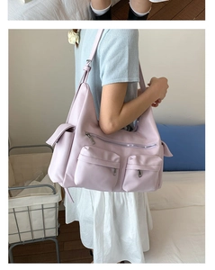 Detailansicht der fliederfarbenen Kunstledertasche mit vielen Taschen und verstellbarem Gurt