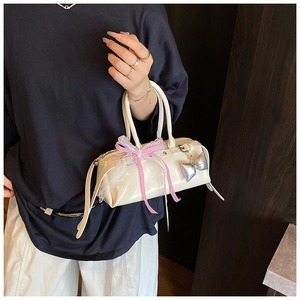 Détail du sac à main en cuir PU crème avec nœud en dentelle rose et breloque argentée