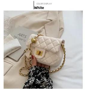 Detail van witte gewatteerde crossbodytas met gouden ketting en verstelbare metalen bal