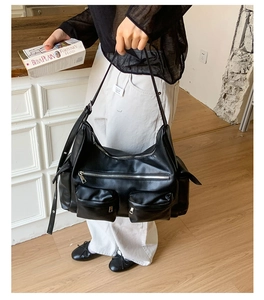 Detail der schwarzen Kunstledertasche mit funktionalen Außentaschen und Metall-Zippern
