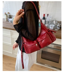 Rote Utility-Tragetasche mit großen Cargo-Taschen, präsentiert von einem Modell in der Küche