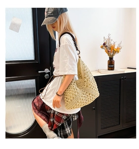 Detail of hand-woven beige hollow tote bag featuring dark brown wooden bead shoulder strap