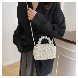 Détail du sac bandoulière en perles tissées avec une grande poignée et chaîne en métal