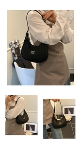 Detail of black lychee grain leather hobo bag with adjustable strap and white square logo