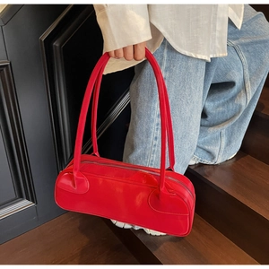 Detail of red rectangular leather handbag with dual long straps and zipper closure