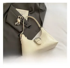 Detail showing the creamy white hobo bag with adjustable strap and metallic buckle design