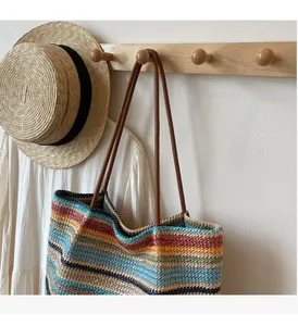 Detail of multi-color striped woven tote with premium brown leather handles and texture