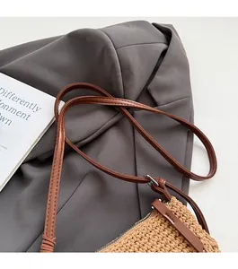 Detailed view of durable brown faux leather shoulder strap and woven texture on tote bag
