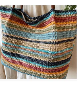 Close-up of rainbow striped woven tote bag featuring durable brown leather handles