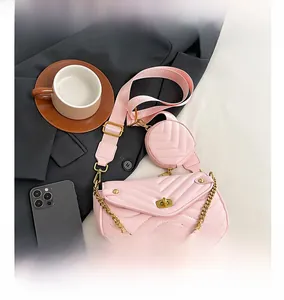 Detail of pink quilted shoulder bag with gold twist lock, chain, and round pouch