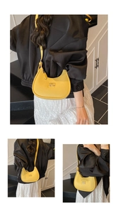 Detail view of yellow lychee leather crescent bag showing COIN 20N logo and shoulder strap