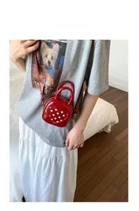 Close-up of red heart-shaped mini bucket bag with polka dot pattern and top handle