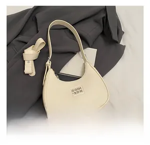 Detail of creamy white crescent shoulder bag featuring premium lychee texture leather