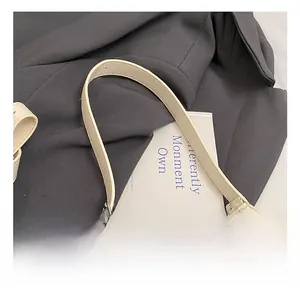 Macro view of creamy beige pebbled leather texture and reinforced stitched handle