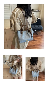 Dettaglio borsa a mano testurizzata grigio-blu con cinturini in pelle marrone e fibbie