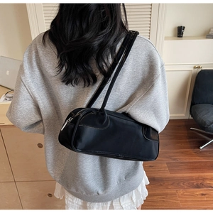 Minimalist black leather Boston bag for women shown as a stylish shoulder underarm bag