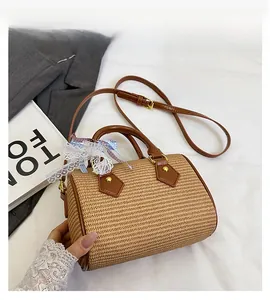 Détail du sac Boston tissé avec garniture en cuir marron et nœud décoratif en dentelle
