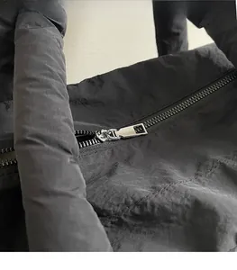 Macro view of smooth silver zipper and quilted waterproof nylon fabric on black tote bag