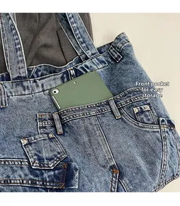 Macro view of denim bag front pocket holding a tablet with contrast stitching