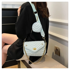 Detail of light blue quilted crossbody bag with gold chain and matching round coin purse