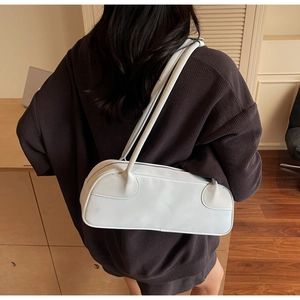 Close-up of minimalist rectangular light blue underarm bag with refined side stitching