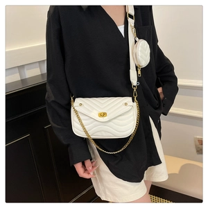 Close-up of a white quilted crossbody bag with small round pouch and wide shoulder strap