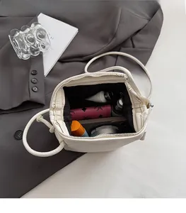 Spacious interior of a cream pebbled leather handbag showing daily essentials and pockets
