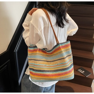 Detailed view of colorful striped woven tote bag with slim brown shoulder straps