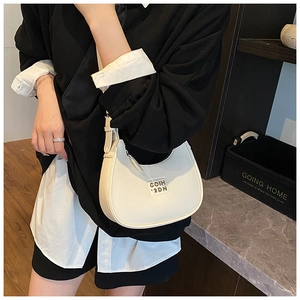 Detailed macro view of white lychee pattern leather and crescent shape on a chic handbag