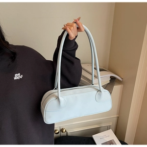 Detail of light blue leather Boston bag with long straps and silver zipper closure