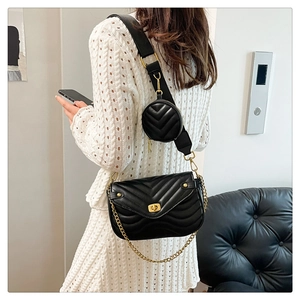 Detail of black quilted shoulder bag with gold twist lock and mini round coin purse