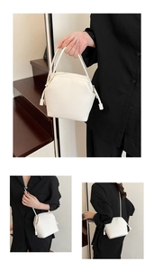 Detailed view of white lychee-textured hexagonal bag with zippers and strap