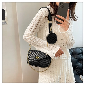 Detail of black quilted shoulder bag with gold twist lock and adjustable chain strap