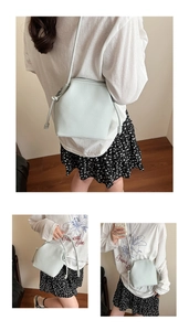 Detailed close-up of mint green litchi grain leather bucket bag with drawstring detail